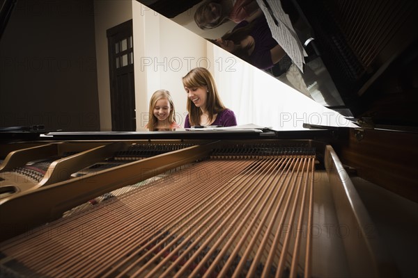 Girl (8-9) and mother playing grand piano. Photo : Mike Kemp