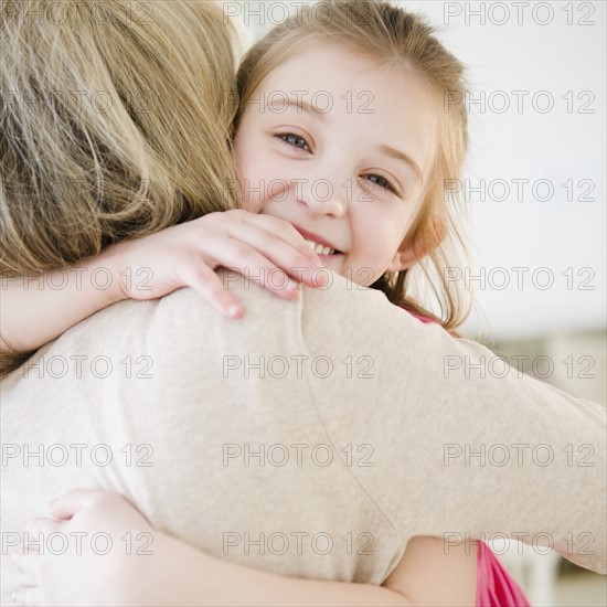 Mother and daughter (10-11) hugging. Photo: Jamie Grill Photography