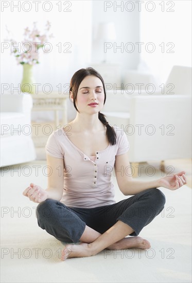 Woman practicing yoga at home. Photo : Daniel Grill