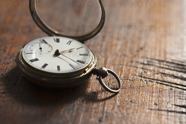 Close up of pocket watch on scratched table.