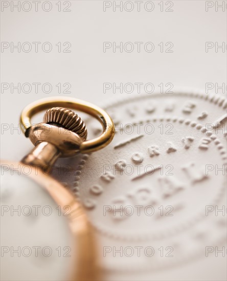 Close up of pocket watch and corporate seal.