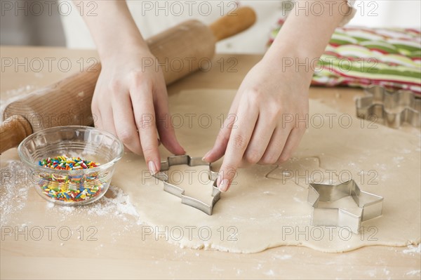 Woman preparing biscuits with pastry cutter.