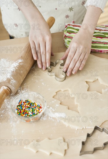 Woman preparing biscuits with pastry cutter.