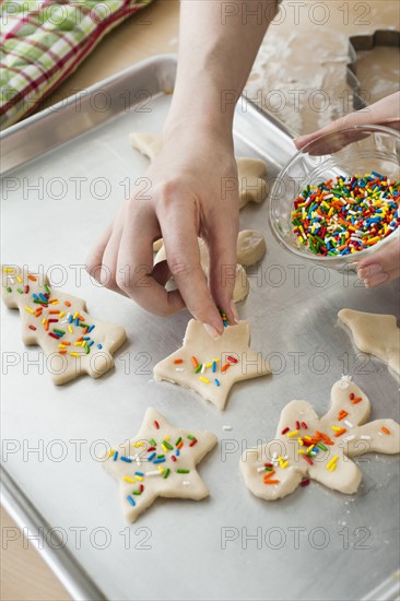 Woman preparing biscuits with pastry cutter.