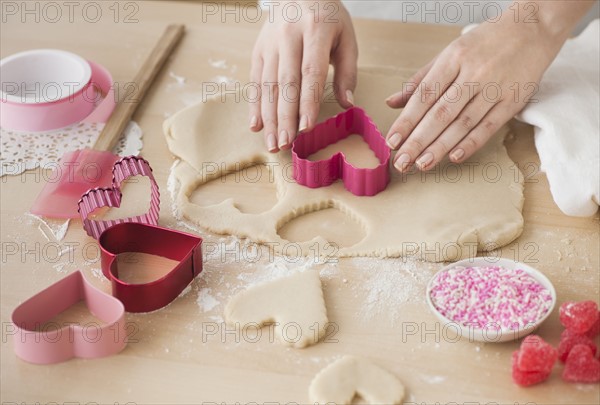 Woman preparing biscuits with pastry cutter.