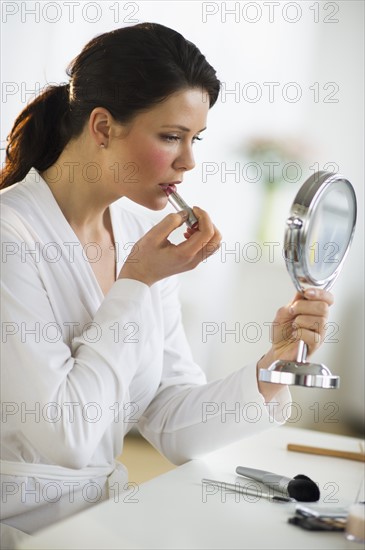Woman applying lipstick.