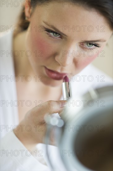 Woman applying lipstick.