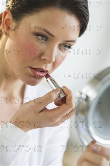 Woman applying lipstick.