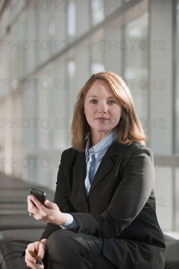 Businesswoman text-messaging. Photo : Mark Edward Atkinson