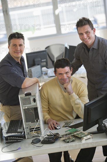 IT Professionals repairing computer in office.