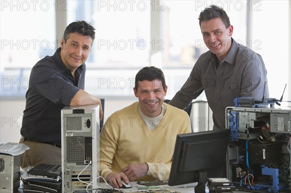 IT Professionals repairing computer in office.