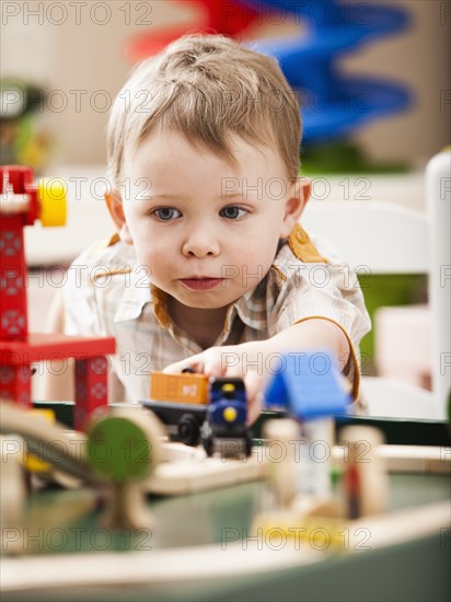 Boy (2-3) playing with toy train. Photo : Mike Kemp