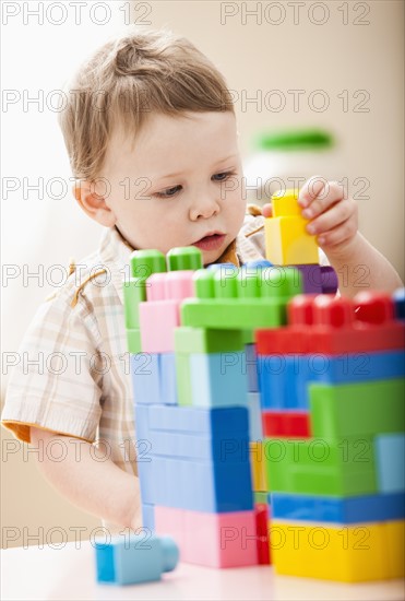 Boy (2-3) playing with colorful blocks. Photo : Mike Kemp