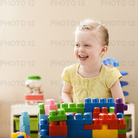 Smiling girl (2-3) playing with colorful blocks. Photo : Mike Kemp