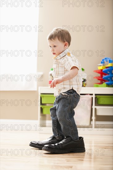 Boy (2-3) walking in dad's shoes. Photo : Mike Kemp