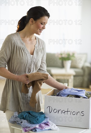Woman preparing clothing for donation.