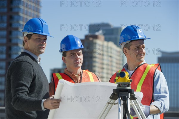 USA, New Jersey, Jersey City, construction workers reading blueprint.