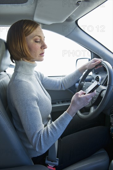 Woman driving car and text messaging.