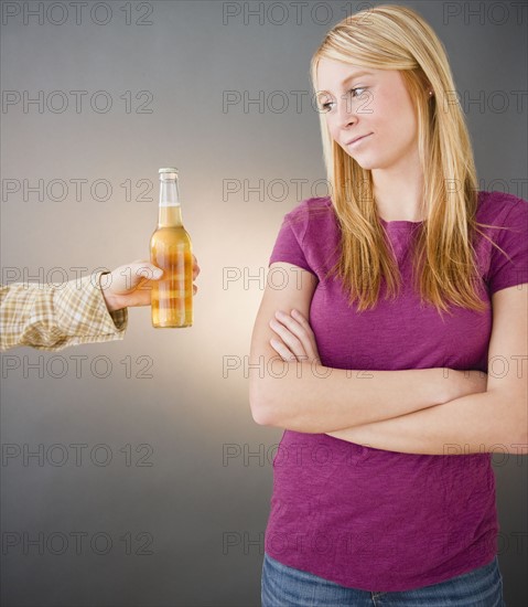 Young woman being offered beer. Photo : Jamie Grill Photography