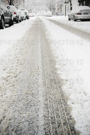 USA, New York State, Brooklyn, Williamsburg, tire track on snow covered street. Photo : Jamie Grill Photography