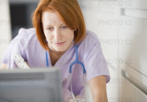 Female nurse using computer. Photo : Jamie Grill Photography