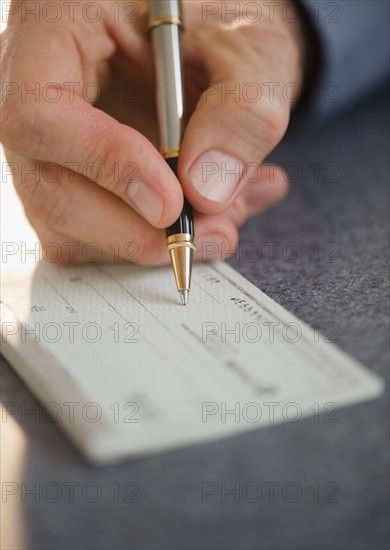 Hand signing check. Photo : Jamie Grill Photography