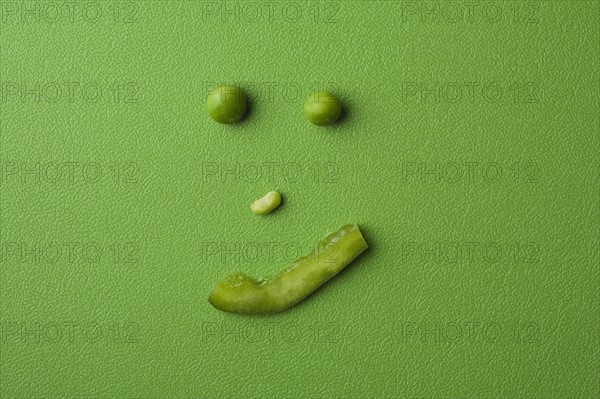 Anthropomorphic face made up from green peas. Photo : Kristin Lee