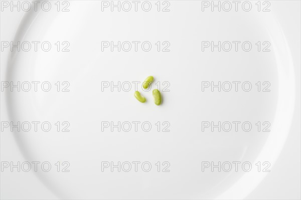 Peas on white plate forming recycling symbol. Photo : Kristin Lee