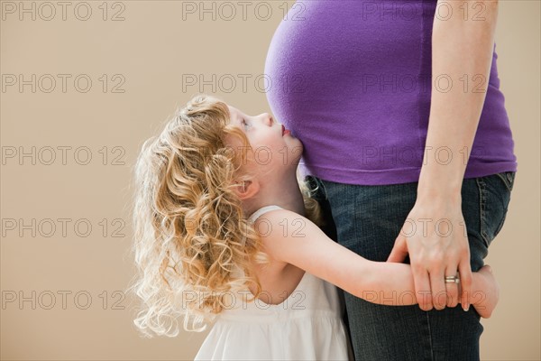 Girl (2-3) and pregnant mother holding hands. Photo : Mike Kemp