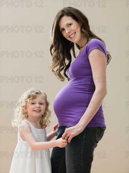 Portrait of girl (2-3) and pregnant mother. Photo : Mike Kemp