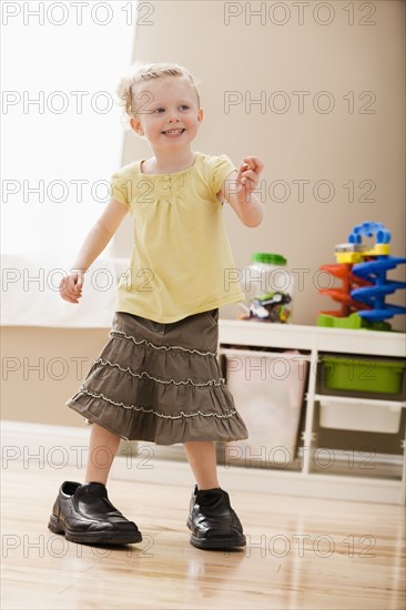 Girl (2-3) walking in dad's shoes. Photo : Mike Kemp