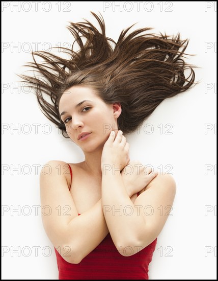 Studio portrait of young woman with windswept hair. Photo : Mike Kemp