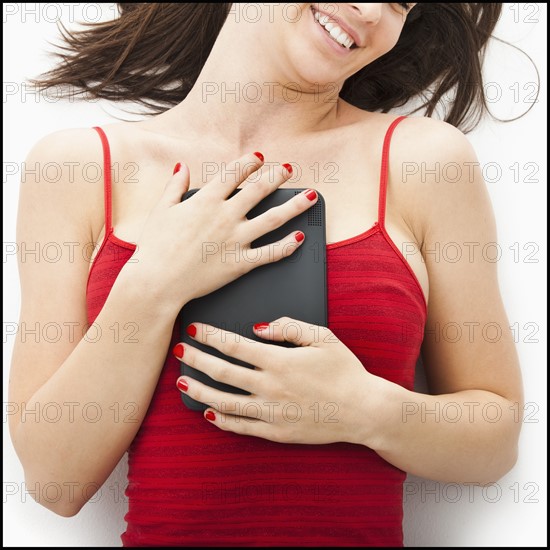 Young woman embracing electronic organizer. Photo : Mike Kemp