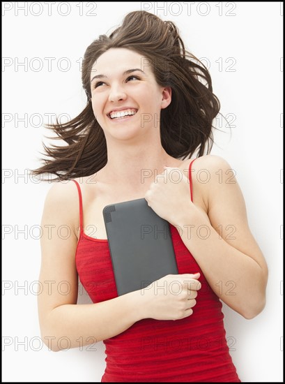 Young woman embracing electronic organizer. Photo : Mike Kemp