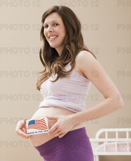 Young pregnant woman holding Made in the USA Sign. Photo: Mike Kemp