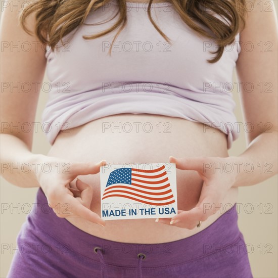 Young pregnant woman holding Made in the USA Sign. Photo : Mike Kemp