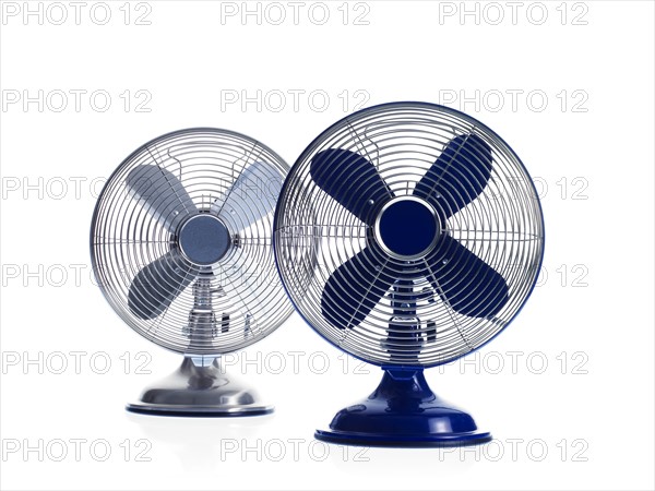 Two electric fans on white background. Photo : David Arky
