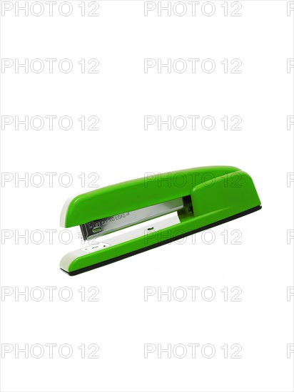 Green stapler on white background. Photo : David Arky