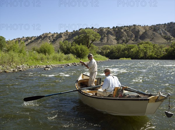 USA, Colorado, Pair of men fly-fishing on mountain river. Photo: John Kelly