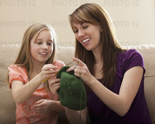 Mother giving daughter (8-9) knitting tips. Photo : Mike Kemp