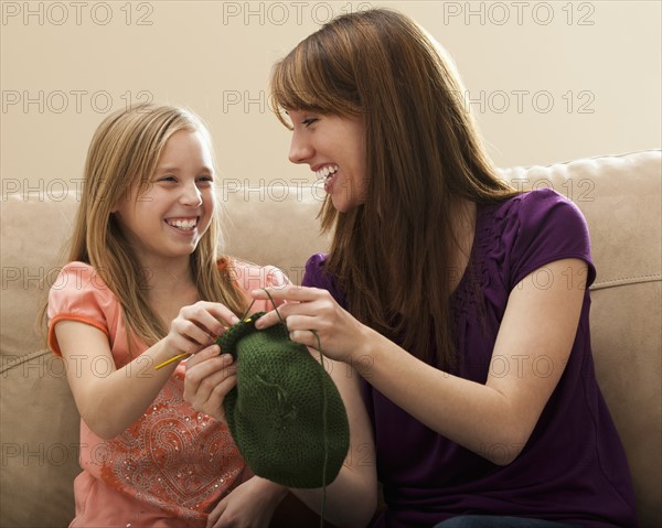 Mother giving daughter (8-9) knitting tips. Photo : Mike Kemp