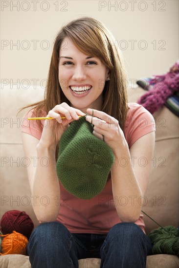 Young woman knitting woolly hat. Photo : Mike Kemp