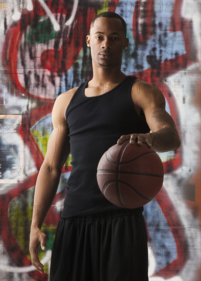 USA, Utah, Salt Lake City, portrait of basketball player in front of graffiti. Photo : Mike Kemp