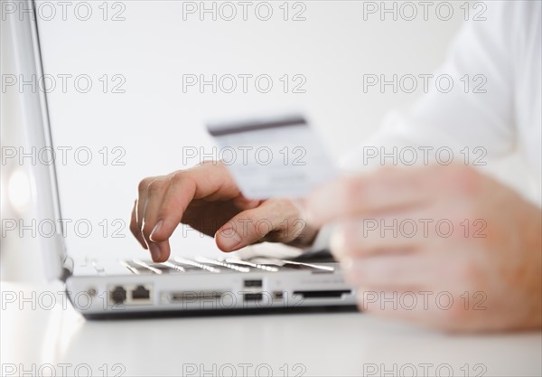 Man shopping online, close-up of hands. Photo: Jamie Grill Photography