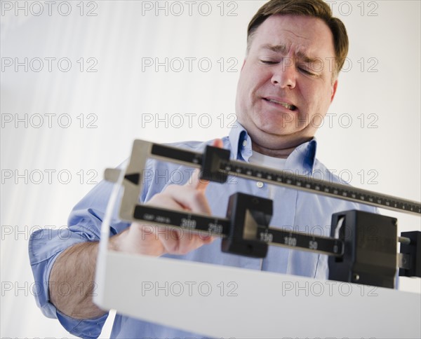 Man on weight scales. Photo: Jamie Grill Photography