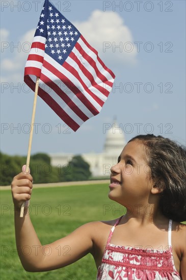 USA, Washington DC, girl (10-11) with US flag in front of Capitol Building. Photo : Chris Grill