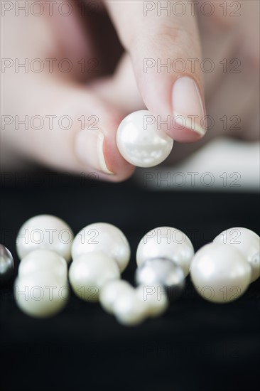 Woman holding pearl.