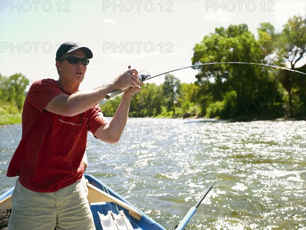 USA, Colorado, Man fly-fishing from boat. Photo : John Kelly