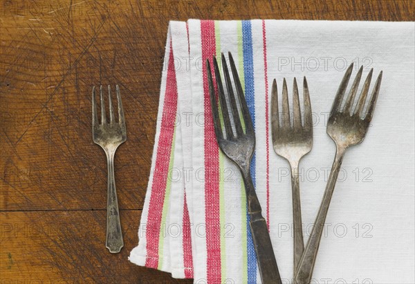 Close up of rusty silver forks and napkin.