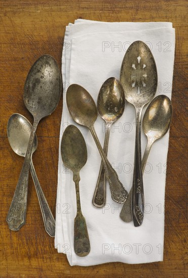 Close up of rusty silver spoons and napkin.